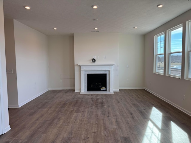 unfurnished living room featuring dark hardwood / wood-style floors and a textured ceiling