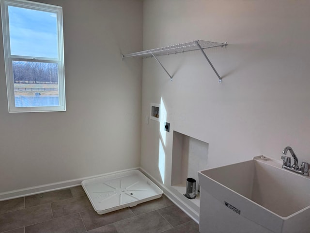 washroom featuring hookup for a washing machine, electric dryer hookup, sink, and dark tile patterned floors