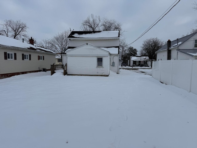 view of snow covered back of property