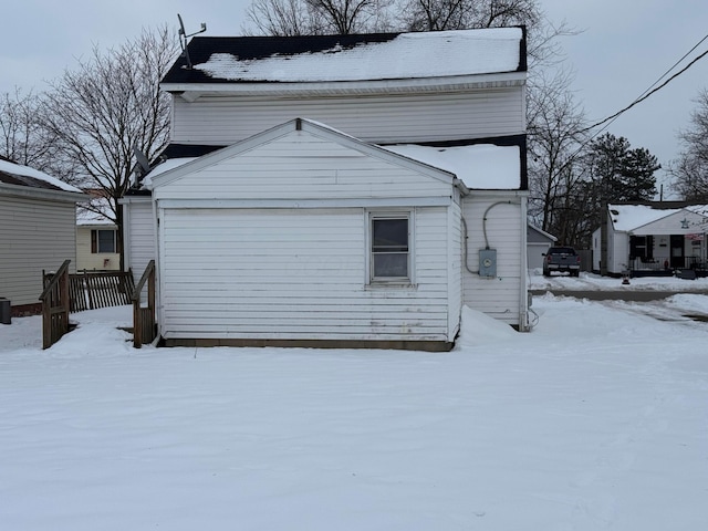 view of snow covered exterior featuring a garage