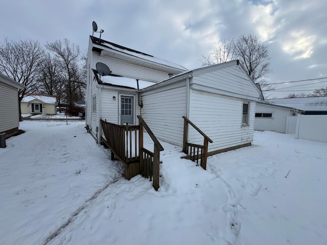 view of snow covered rear of property