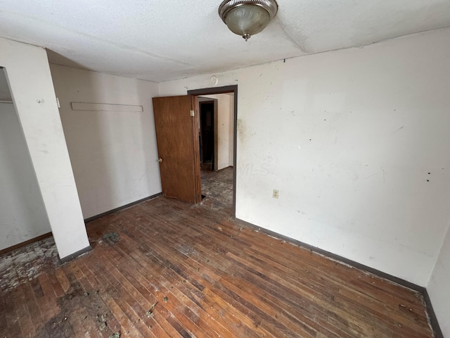 unfurnished bedroom with dark hardwood / wood-style flooring and a closet