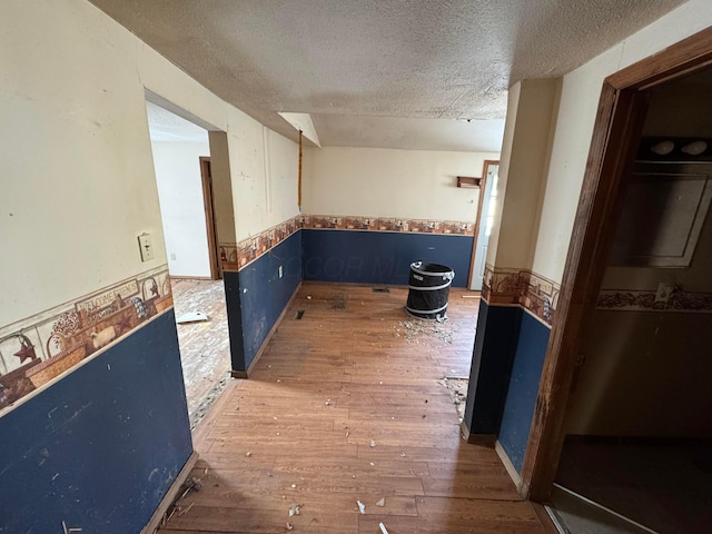 hallway featuring wood-type flooring and a textured ceiling