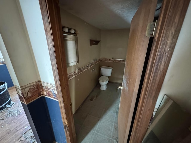 bathroom featuring a textured ceiling, vanity, and toilet