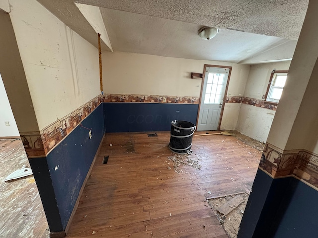 unfurnished room with a textured ceiling and hardwood / wood-style floors