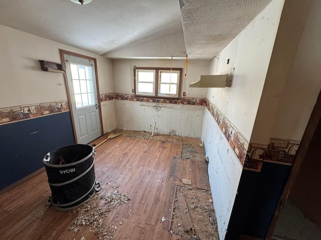 kitchen featuring lofted ceiling, wood-type flooring, and a textured ceiling