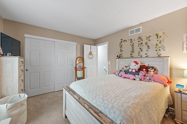 bedroom featuring visible vents, light carpet, and a closet