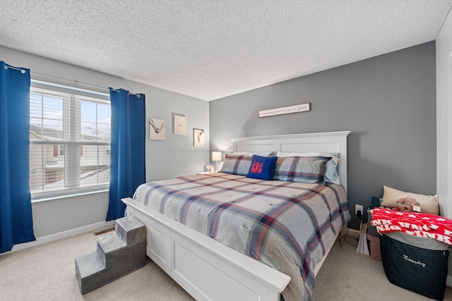 carpeted bedroom with a textured ceiling and baseboards