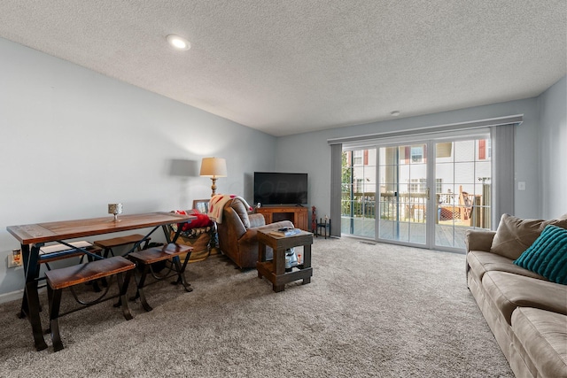 living area with visible vents, carpet floors, and a textured ceiling