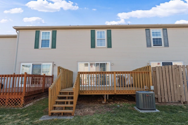 back of property featuring a lawn, central AC unit, a deck, and fence