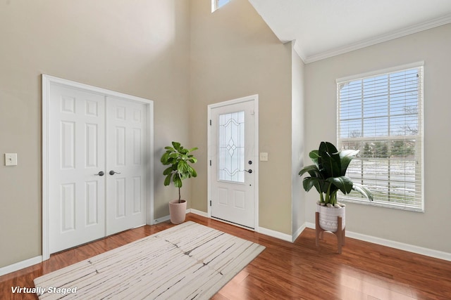 entrance foyer featuring crown molding, plenty of natural light, and hardwood / wood-style floors