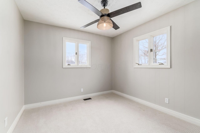 spare room featuring carpet floors, ceiling fan, and a healthy amount of sunlight