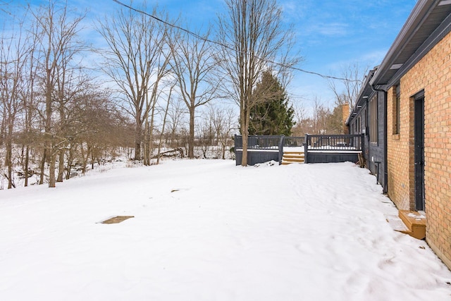 snowy yard with a wooden deck