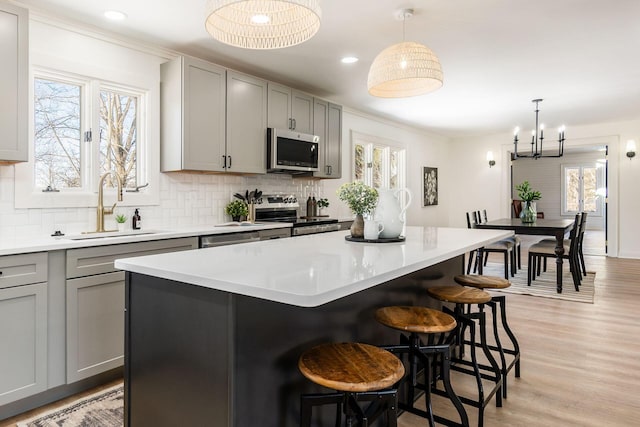 kitchen with a center island, gray cabinets, and stainless steel appliances