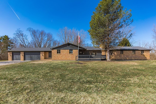 view of front of home featuring a front yard, brick siding, a garage, and driveway