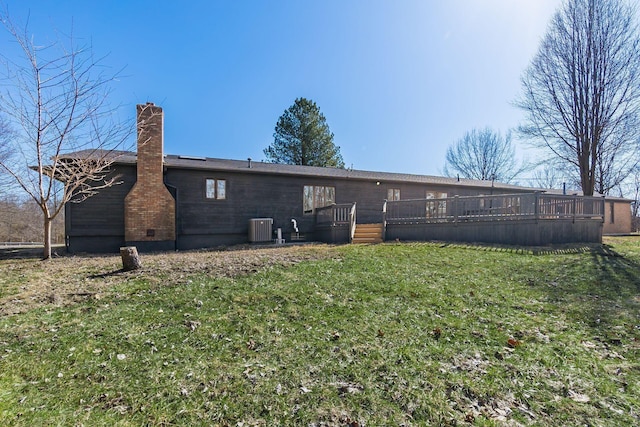 rear view of house with a deck, a lawn, a chimney, and central AC