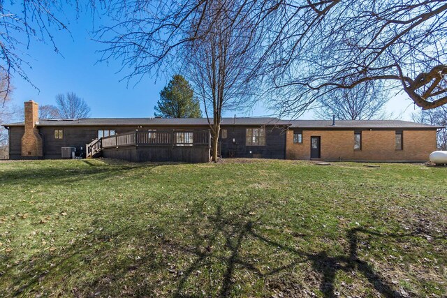 back of house with a wooden deck, central air condition unit, a lawn, and a chimney