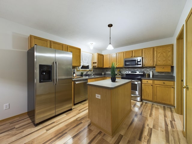 kitchen with a kitchen island, stainless steel appliances, tasteful backsplash, hanging light fixtures, and light wood-type flooring