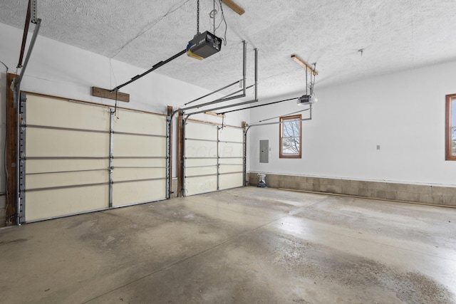 garage with a garage door opener and electric panel