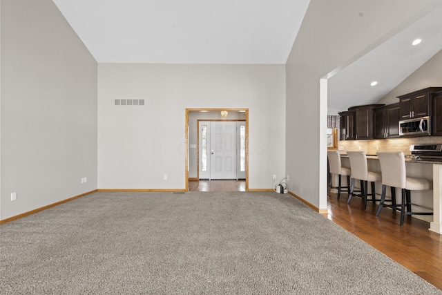 living room with vaulted ceiling and dark carpet