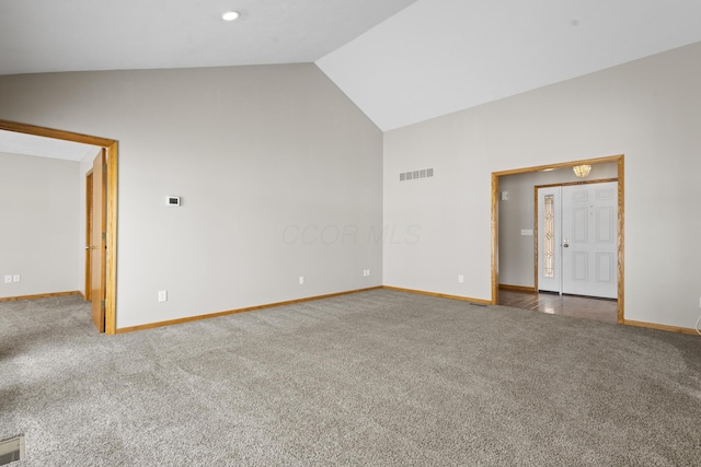 unfurnished room with carpet flooring and high vaulted ceiling