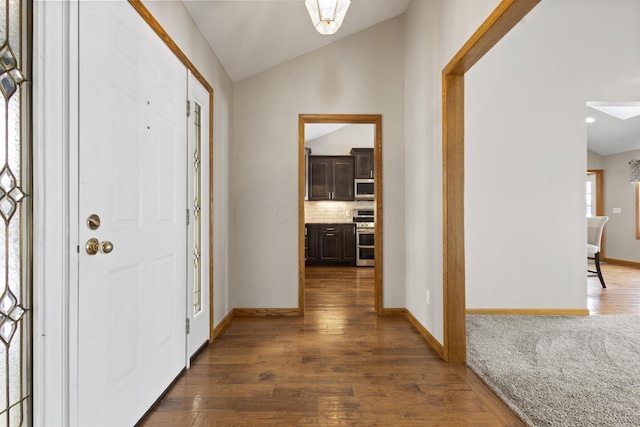 foyer entrance with vaulted ceiling and dark hardwood / wood-style floors