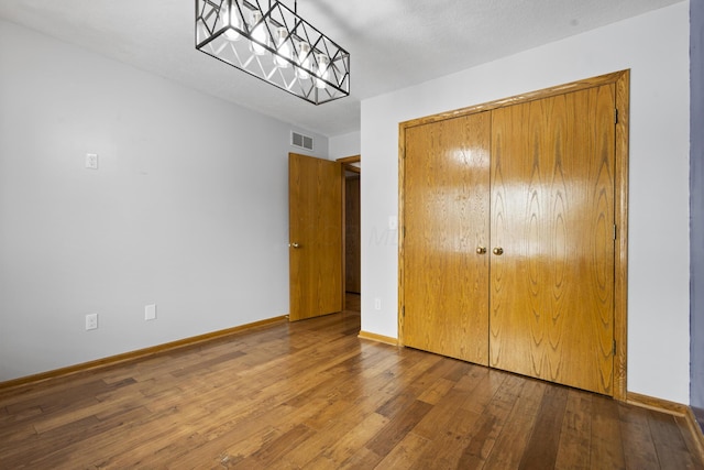 unfurnished bedroom featuring hardwood / wood-style floors and a closet