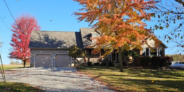 view of front of home with a garage, a front yard, and a porch