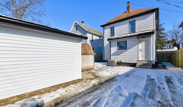 snow covered back of property with central air condition unit