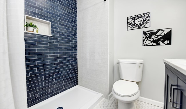 bathroom featuring tile patterned flooring, vanity, toilet, and walk in shower