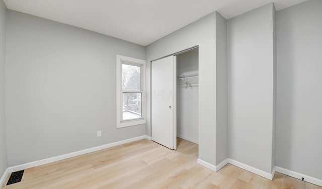 unfurnished bedroom featuring light wood-type flooring and a closet