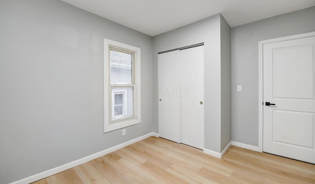 unfurnished bedroom with light hardwood / wood-style flooring and a closet