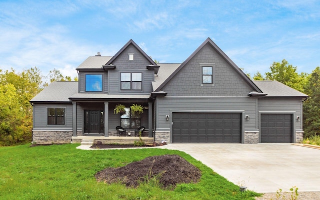 craftsman-style house featuring a front yard, covered porch, and a garage