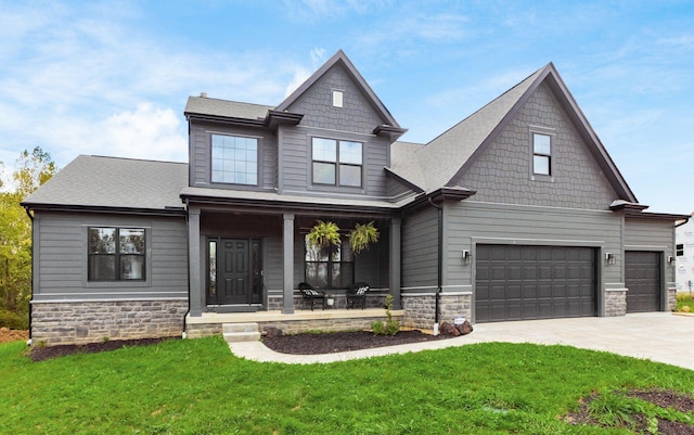 craftsman-style home featuring a garage, a front yard, and a porch