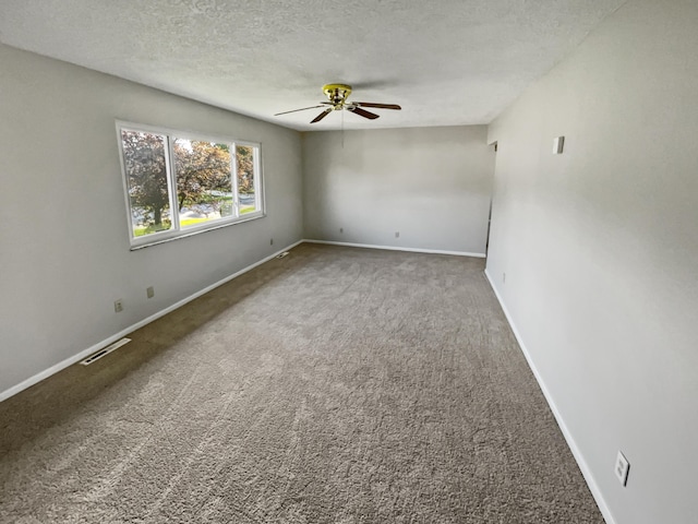 carpeted spare room with a textured ceiling and ceiling fan