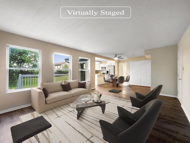 living room with a textured ceiling, hardwood / wood-style floors, and ceiling fan