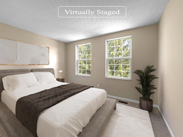 bedroom with a textured ceiling and carpet