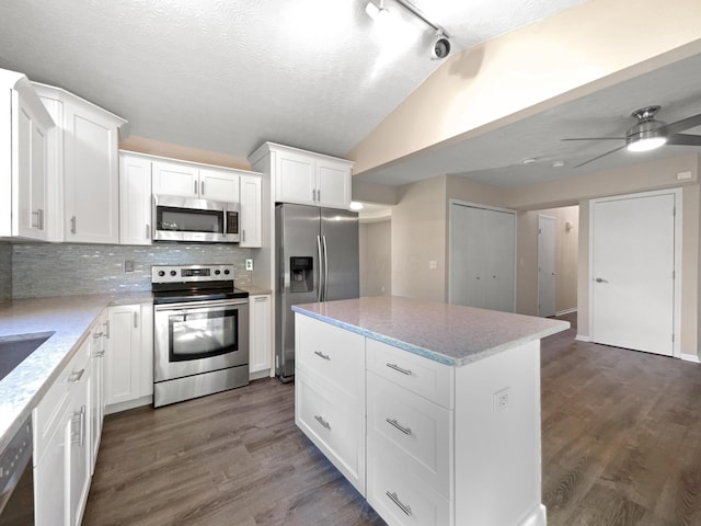 kitchen featuring appliances with stainless steel finishes, white cabinets, a textured ceiling, and decorative backsplash