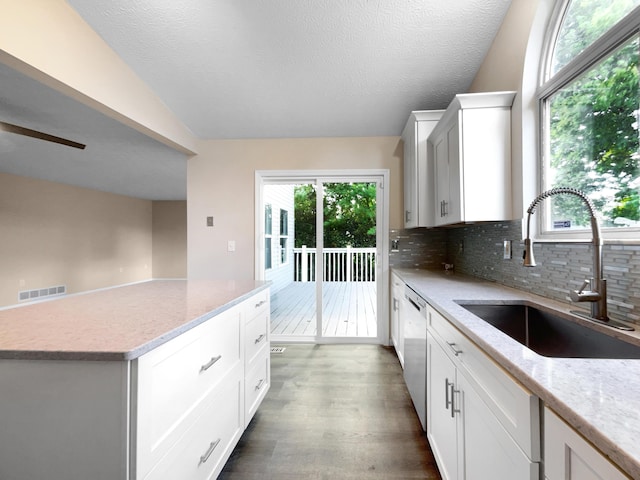 kitchen with sink, stainless steel dishwasher, white cabinets, and decorative backsplash