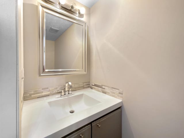 bathroom with a textured ceiling and vanity