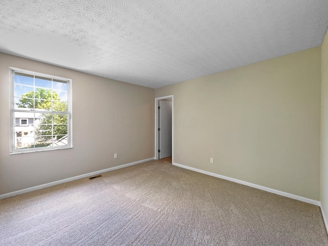 unfurnished room featuring carpet flooring and a textured ceiling