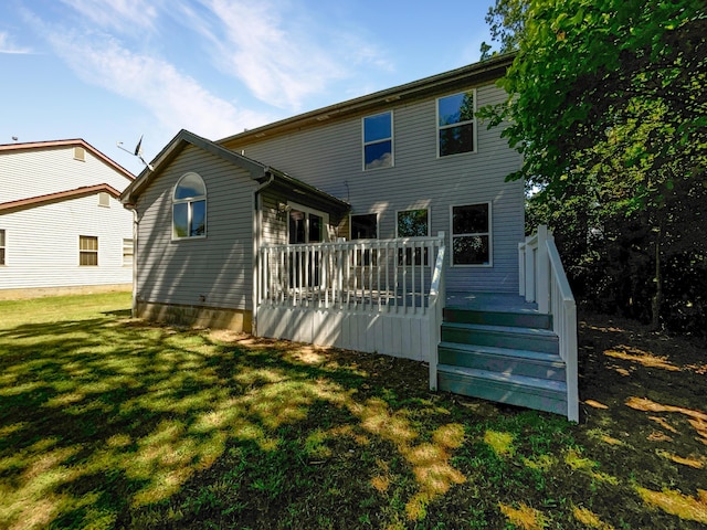 rear view of property featuring a lawn and a deck