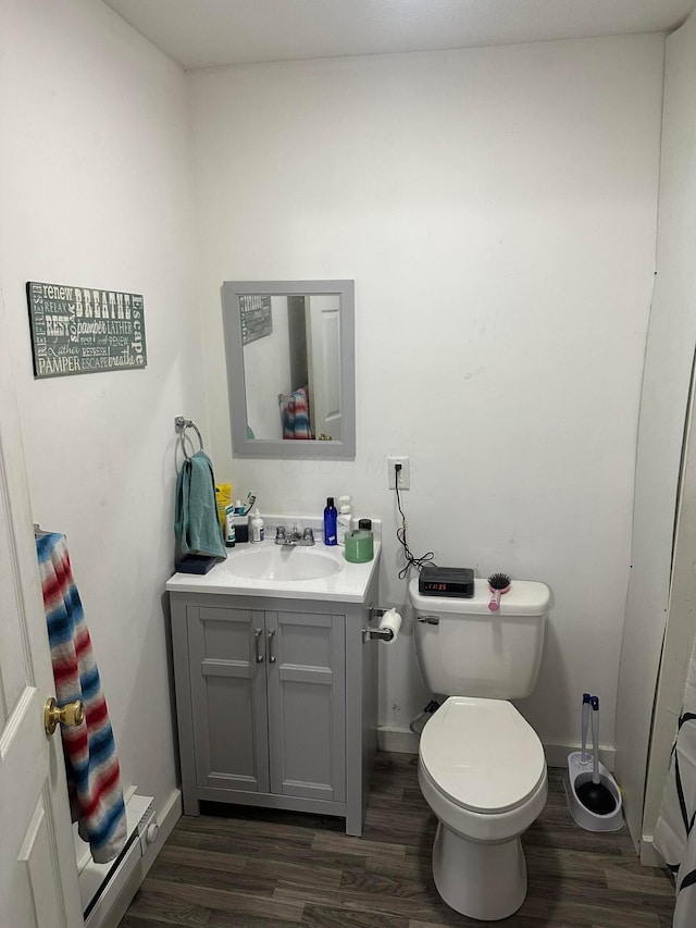 bathroom with toilet, wood-type flooring, and vanity