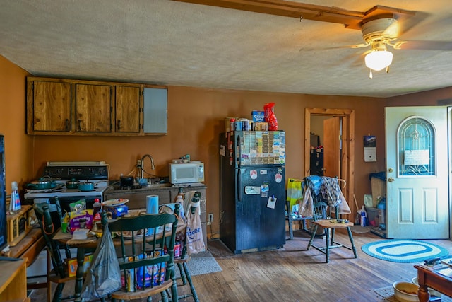 22 Fairlawn Ave, Glouster, OH 45732 - kitchen featuring freestanding refrigerator, white microwave, hardwood / wood-style floors, ceiling fan, and brown cabinetry