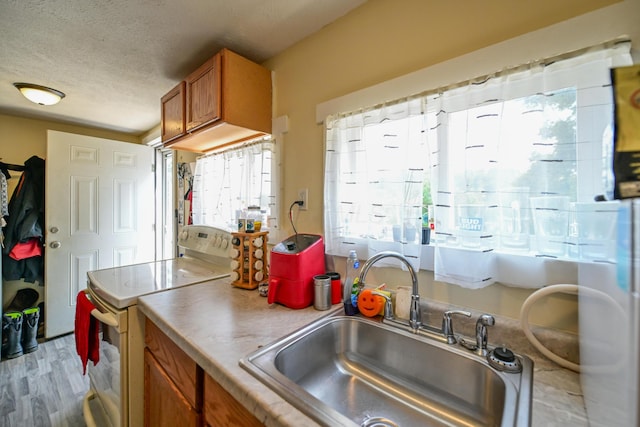 22 Fairlawn Ave, Glouster, OH 45732 - kitchen with white range with electric cooktop, brown cabinets, plenty of natural light, a textured ceiling, and wood finished floors