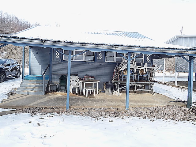 view of snow covered back of property