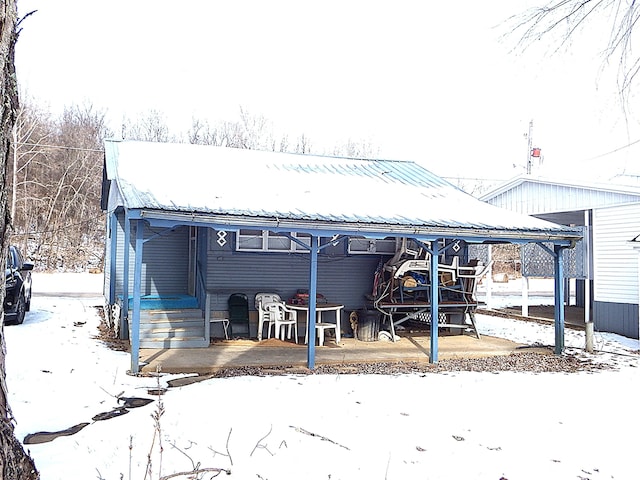 view of snow covered rear of property