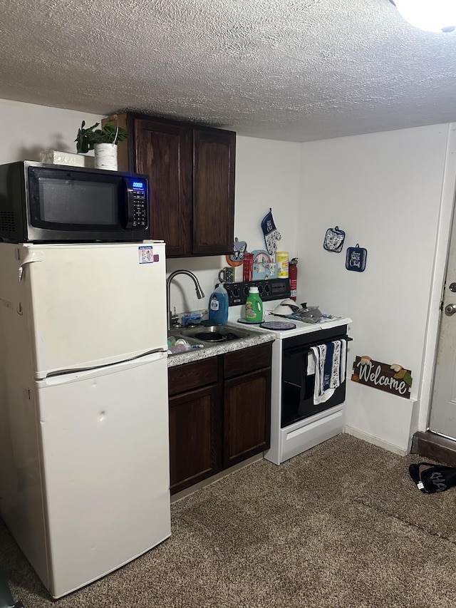 kitchen featuring white fridge, carpet, a textured ceiling, dark brown cabinetry, and sink