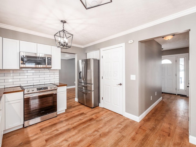 kitchen with light wood-style floors, baseboards, appliances with stainless steel finishes, and white cabinets