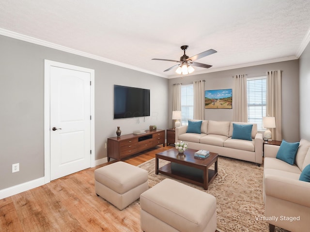 living area featuring ornamental molding, light wood-type flooring, a ceiling fan, and baseboards